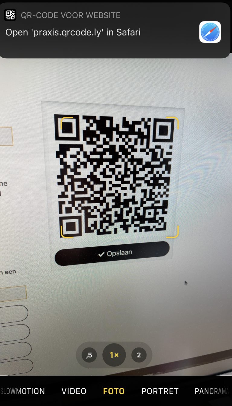 Telefoon scant een QR-code en toont praxis.qrcode.ly als scan-URL in beeld