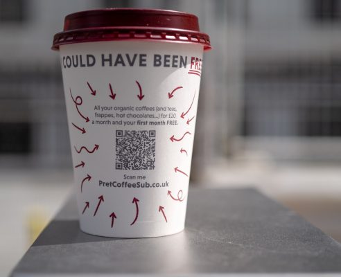 Wegwerp koffiebeker, waarop een QR-code staat voor meer informatie.